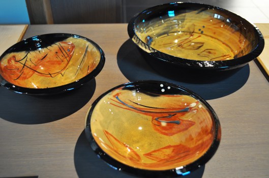 Son interprétation très personnelle de la technique de la terre vernissée donne à ses décors une luminosité et une profondeur évoquant les laques extrêmes orientales.